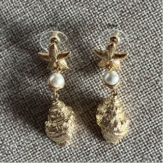 
                    
                      Goldene Statement Ohrringe mit Muschel und Perle
                    
                  